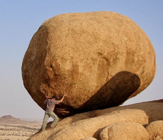 Man pushing boulder (tenacious work ethic)