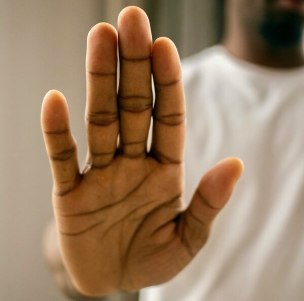 Man putting up hand to deny hate