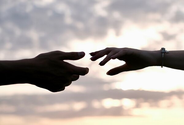 Two people reaching out to connect to each other