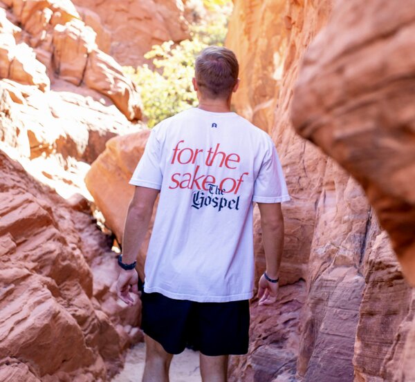 Man wearing "for the sake of the gospel" shirt expressing need for evangelism despite predestination