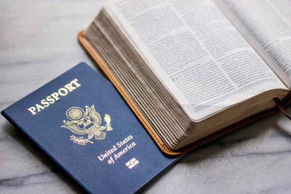 Passport and Bible together highlighting single Christian's ability to serve "without care"