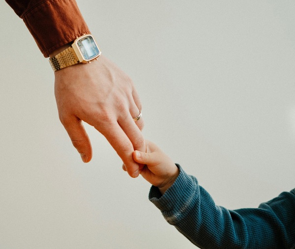 Parent holding child's hand to lead them
