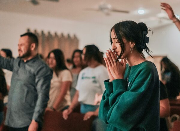 woman in church together with other Christians