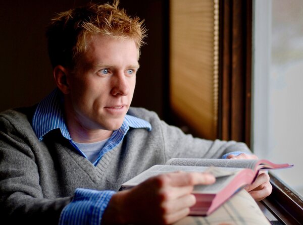 Man with a Bible looking out of window