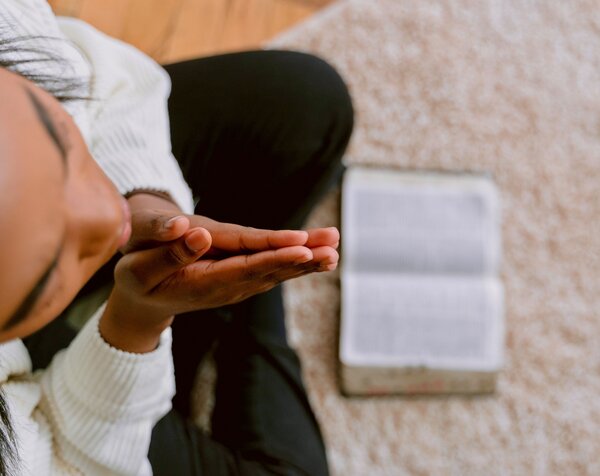 woman praying alone with Bible